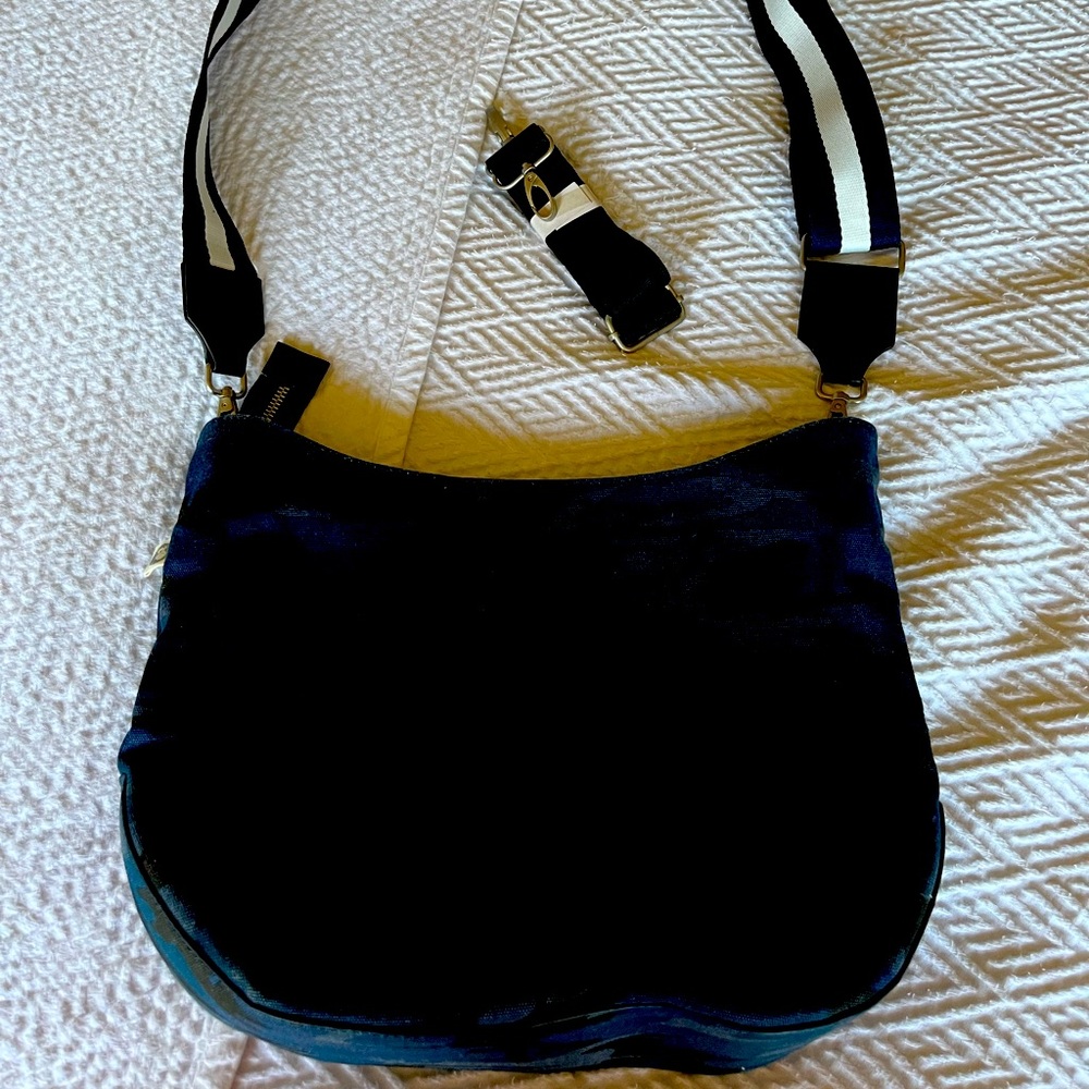 Never used, very roomy, comes with a solid black replacement strap